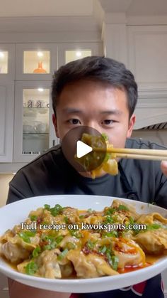 a man holding a plate of food with chopsticks