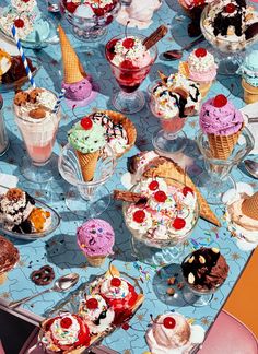 a table topped with lots of ice cream and desserts