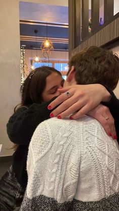 two people are hugging each other in the kitchen