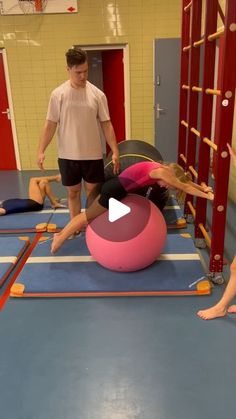 two people are doing exercises on an exercise ball while another man watches from the sidelines