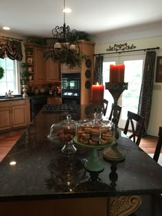 a large kitchen island with cookies on it and two candles in the center, surrounded by chairs