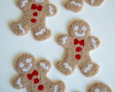 several small teddy bears made out of knitted material with red and white hearts on them