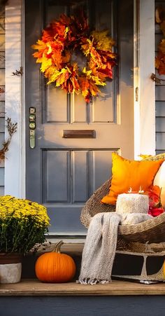 the front porch is decorated for fall with pumpkins and other decorations