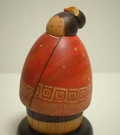 a wooden figurine with a red and black design on it's head