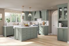 a large kitchen with green cabinets and white counter tops, along with hardwood floorsing