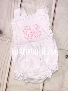 This white ruffled romper is so cute and comfy ! Perfect for summer and every day wear ! 100 % cotton, knit fabric (so soft!) Elastic in leg opening Snaps in crotch  Buttons at shoulder PERSONALIZATION CAN BE IN ANY COLOR ! (light pink shown with vine monogram - hot pink shown in Fancy monogram) Please leave the name or full name (for monogram) in the notes to seller section during checkout, along with thread color  Other designs available ! Please message me to start your custom order :) any ot Cotton Ruffle Onesie For Playwear, Cotton Onesie With Ruffles For Playwear, Spring Bubble Romper With Ruffled Straps, Spring White Ruffled Onesie, Fitted Ruffle Onesie For Summer, Cute Bubble Romper With Ruffle Hem For Spring, Personalized Fitted Onesie For Spring, Cute Spring Bubble Romper With Ruffle Hem, Summer White Cotton Bubble Romper