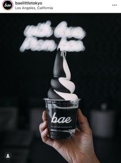 someone is holding up a cup with ice cream in it that has the word bae on it