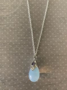 "Lovely moonstone white teardrop shaped necklace featuring silver tone regal motif with purple inlaid gem stone. Pendant measures 7/8\" L X 1/2\" W and is on an 18\" chain. Note: This is a slightly smaller version of this necklace sold prior to 6/30/20. Also available with a black stone under the following listing: https://www.etsy.com/listing/858843851/moonstone-necklace-moon-stone-necklace?ref=listings_manager_grid ★ Want to see more? Please visit my shop at: https://www.etsy.com/shop/DesignsB Moonstone Necklace Pendants, Moon Stone Jewelry, Gem Stones Jewelry, Moon Stone Necklace, Gem Stone Pendant, Gem Stone Necklace, Purple Stone Necklace, Simple Silver Jewelry, Moonstone Pendant Necklace