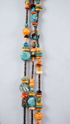 a multi - colored beaded necklace hanging on a wall