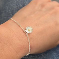 This delicate sterling silver daisy bracelet captures the delicate beauty of a blooming daisy. The bracelet features a bobble chain design that adds a playful touch to the piece. At the centre of each daisy is a mixed metal accent, blending warm gold tones with the cool elegance of silver to create a stunning contract. Perfect for stacking. The bracelet is 19.00cm Your purchase will arrive in a organza pouch, but if you would like a luxury gift box, as illustrated, then please select from the dr Dainty Sterling Silver Bracelets, Adjustable Delicate Sterling Silver Bracelet, Handmade Dainty Sterling Silver Bracelet, Tiny Adjustable Sterling Silver Bracelets, Dainty Flower Chain Bracelet As Gift, Dainty Flower Chain Bracelet For Gifts, Dainty White Gold Flower Bracelet, Dainty Flower Shaped Chain Bracelet For Gift, Dainty Sterling Silver Bracelet With Flower Charm