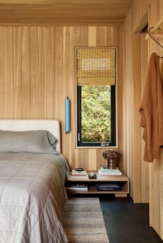 a bedroom with wood paneling and a bed