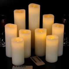 many lit candles with remote controls on the table