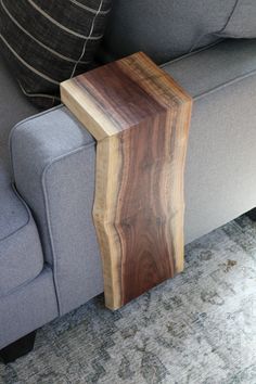 a wooden table sitting on top of a gray couch