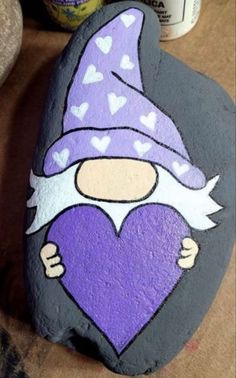 Nome Rock Painting, How To Paint Gnomes On Rocks, Gnome Rock Painting Ideas Easy, Gnomes Painted On Rocks, Purple Painted Rocks, Rock Painting Gnomes, Gnomes On Rocks, Valentine Rock Painting Ideas, Gnome Rock Painting Ideas