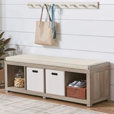 a wooden bench with two baskets and a pink bag hanging on the wall above it