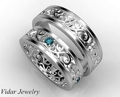 two white gold wedding bands with blue topaz stones and filigrees on them