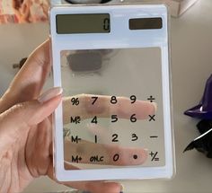 a person holding up a calculator with numbers on it