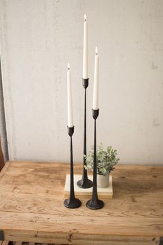 three candles are sitting on a wooden table