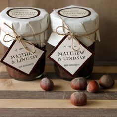 two jars filled with nuts sitting on top of a wooden table