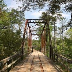 an old rusty metal bridge in the woods