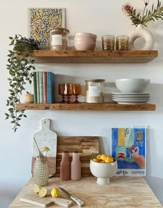 two wooden shelves filled with dishes and vases on top of a kitchen counter next to a cutting board