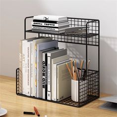 a black metal book shelf with books and pencils