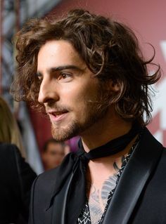 a close up of a person wearing a suit and tie with tattoos on his chest