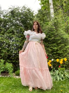 "Lovely 70s pink and white maxi dress with polka dots! I love the ruffle part across the chest. Ribbon at waist. Flowy skirt. Zipper closure at the back. As you can see it is too tight for the model on the back. Fits xs.  Measurements:  ptp 15\"  waist 24\"  hips- 26\"  length  model is size small, 27\" waist, 38\" hips, 34\"B bust, 5\"4 tall." Pink Floor-length Maxi Dress With Ruffle Hem, Pink Floor-length Dress With Ruffle Hem, Pink Ruffled Skirt Maxi Dress For Spring, Fitted Pink Maxi Dress With Ruffled Skirt, Pink Fitted Maxi Dress With Ruffles, Fitted Pink Maxi Dress With Ruffles, Fitted Pink Maxi Dress, Vintage Dresses With Ruffles And Long Skirt, Pink Fitted Maxi Dress