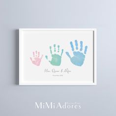 two hand prints are displayed in a white frame on a gray wall with the words mr and mrs george and alex