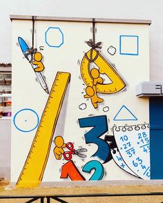 a mural on the side of a building with numbers, rulers and scissors painted on it