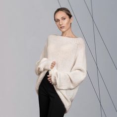 The versatile, luxurious, and elegant silhouette of the sweater ASTRID can be a part of many different looks, at the same time keeping you warm and cosy.  Hand-crafted from premium alpaca and mohair blend, this fluffy pullover features an oversized fit, raglan shoulder construction and extra-long sleeves. Style with jeans for a more casual look, or elegant trousers/skirt for an evening. DETAILS -Oversized -Boat neck -Extra-long puff sleeve -Raglan shoulder construction Designed and ethically mad Chic Balloon Sleeve Sweater For Winter, Elegant Chunky Knit Long Sleeve Sweater, Elegant Long Sleeve Chunky Knit Sweater, Elegant Chunky Knit Sweater For Fall, Elegant Oversized Soft Knit Tops, Elegant Cream Soft Knit Sweater, Chic Mohair Long Sleeve Sweater, Elegant Mohair Crew Neck Sweater, Elegant Mohair Sweater For Fall