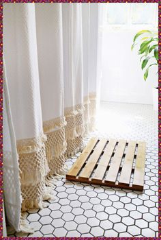 a wooden pallet sitting on top of a white tiled floor next to a window