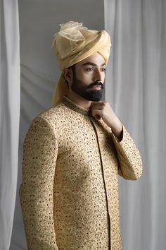 Discover the timeless elegance and regal charm of our Collar Detail Gold Sherwani. Made from pure atlas material, this sherwani features exquisite hand-embroidered jal work of resham, zardozi, Swarovski stones, and dabka. Complete with a jamawar kula (turban) and silk inner kurta pajama, this resplendent piece is perfect for any special occasion. Elevate your style with this luxurious and sophisticated sherwani. 4-Piece Suit Traditional Raw Silk Wear With Naqshi Detailing, Traditional Naqshi Raw Silk Traditional Wear, Gold Sherwani With Resham Embroidery And Kundan, Ceremonial Raw Silk Kurta With Naqshi, Ceremonial Sherwani With Intricate Embroidery In Raw Silk, Gold Sherwani With Intricate Embroidery In Raw Silk, Ceremonial Naqshi Raw Silk Kurta, Ceremonial Raw Silk Dupatta With Naqshi Detail, Bollywood Style Raw Silk Sherwani With Intricate Embroidery