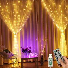 a chair and table with lights on the curtained walls behind it in front of a window