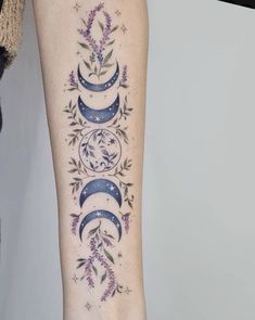 a woman's arm with three phases of the moon and lavender flowers on it