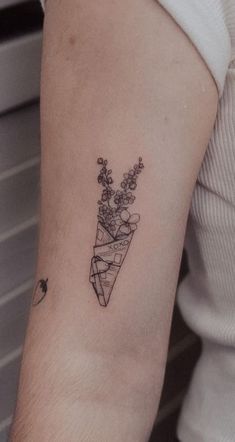 a woman's arm with a tattoo on it that has flowers in the shape of a triangle