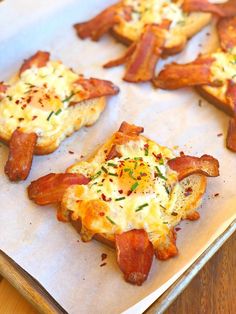 four pieces of bread with bacon and cheese on them