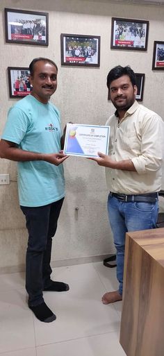 two men standing next to each other holding an award