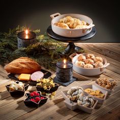 a table topped with lots of different types of desserts and pastries next to candles