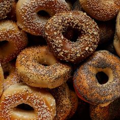 a pile of bagels with sesame sprinkles on them