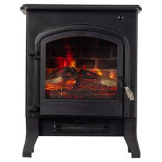 a black stove with red flames in the fireplace and on top of it's stand