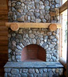 a stone fireplace with logs on the mantle