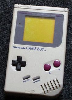 an old nintendo game boy sitting on the ground