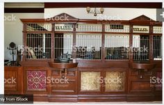 an old fashioned wooden cabinet with metal doors and shelves in the middle of a room