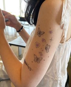 a woman with butterfly tattoos on her arm