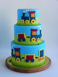 a three tiered cake with train decorations on it