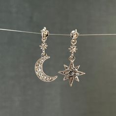 These stunning celestial star and moon charm earring with diamond stainless steel finish . These celestial earrings for any lover of boho jewelry.These super celestial earrings make a wonderful gift for a loved one, friend or relative, or a great way to treat yourself. Cubic Zirconia stones For pierced ears. Height: 3,5 cm Width: 1,5 cm Crescent Moon Stud and Stars Ear Climber https://www.etsy.com/listing/795195743/crescent-moon-stud-and-stars-ear-climber?ref=shop_home_active_13&pro=1&frs=1 Moon Celestial Star Charm Round Earrings, Celestial Sterling Silver Jewelry With Matching Earrings, Sterling Silver Celestial Jewelry With Matching Earrings, Celestial Silver Earrings With Star Charm, Celestial Single Earring Jewelry Gift, Celestial Silver Pierced Jewelry, Celestial Single Earring Jewelry For Gift, Celestial Style Silver Jewelry, Celestial Star-shaped Metal Jewelry