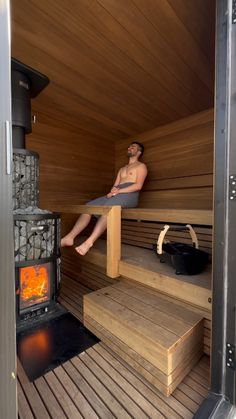 a man is sitting in the sauna with his feet up and legs down on steps