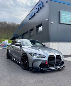 a silver sports car parked in front of a building