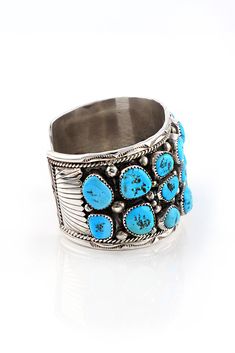 This Men's Kingman Turquoise Row Cuff is outstanding. There are 22 genuine Kingman Turquoise stones in this Navajo men's 1.75" wide cuff bracelet. The row cuff bracelet is a classic and favorite design for Native American men's bracelets. Handmade sterling silver beads surround each bezel set stone. Notice the sterling silver rope and hand stamped border encircleing the cuff. The oxidized patina on this bracelet provides a nice contrast. This bracelet is a must for collectors of Native American Native American Men, Men's Bracelets, Wide Cuff Bracelets, Southwest Style, Turquoise Stones, Kingman Turquoise, Wide Cuff, American Jewelry, Native American Jewelry